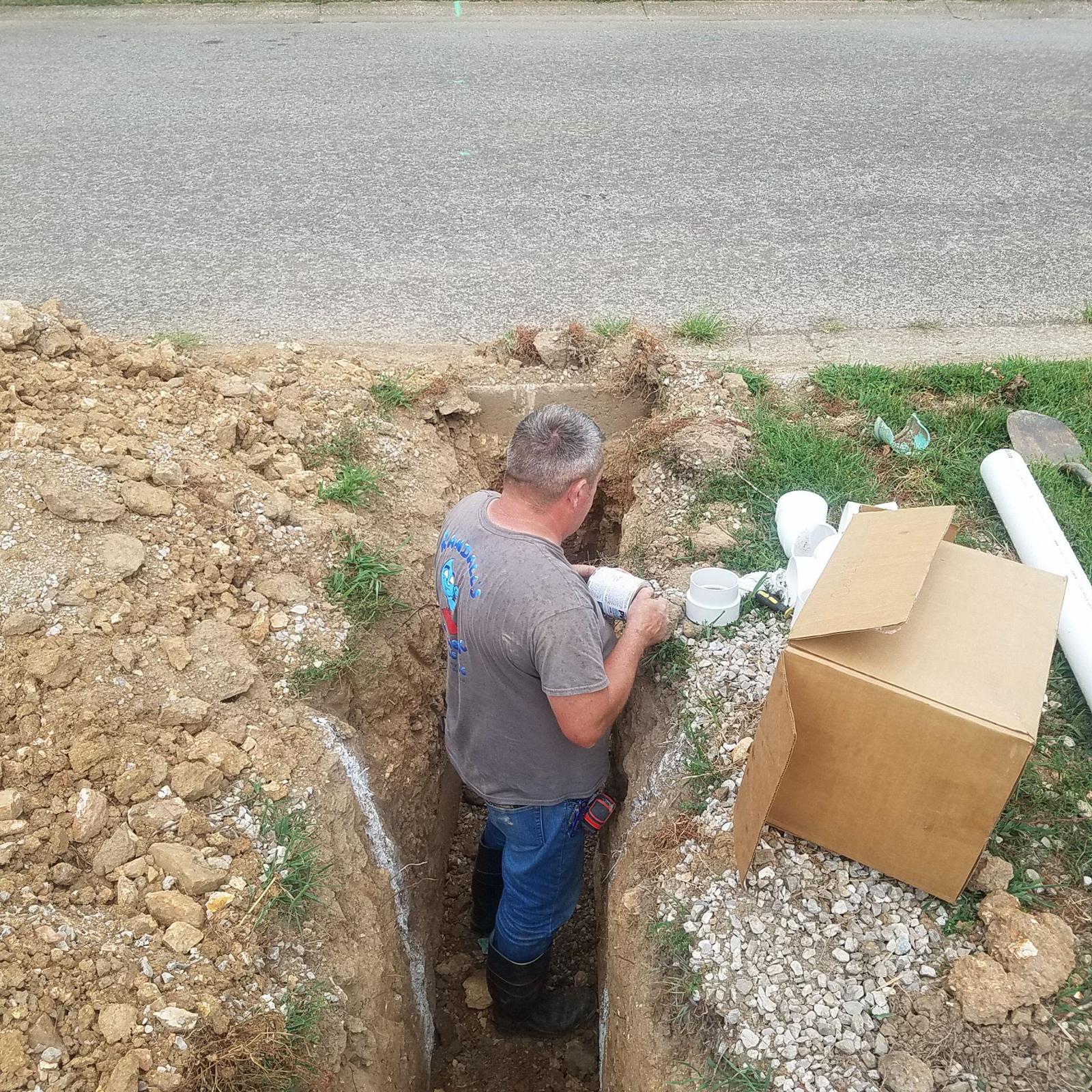 Randy connecting a new sewer drain to the city sewer under the street.