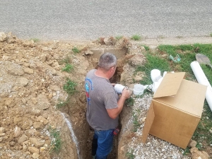 Randy connecting a new sewer drain to the city sewer under the street.