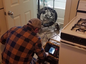 Randall operating his new drain camera that can inspect main drains to locate and record clogs and damaged pipes.